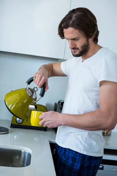 Uomo versando il caffè in tazza in cucina — Foto Stock