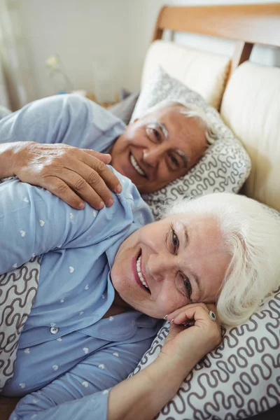 Happy senior couple lying on bed — Stock Photo, Image