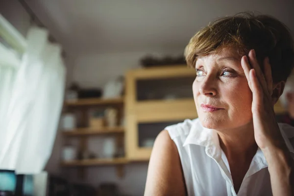 Bezorgd senior vrouw met de hand op het voorhoofd — Stockfoto