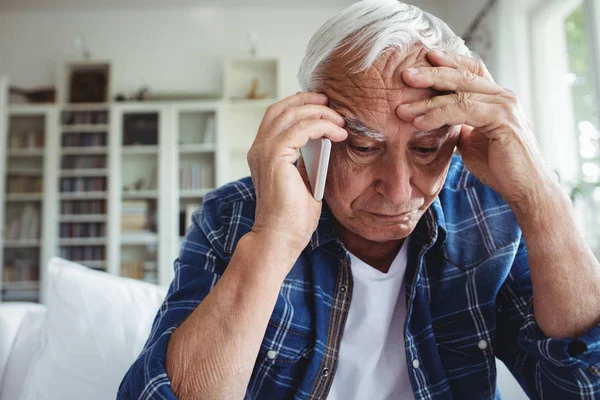 Verkrampte senior man praten over telefoon — Stockfoto