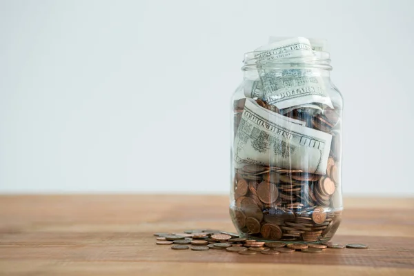 Monedas y billetes en frasco — Foto de Stock