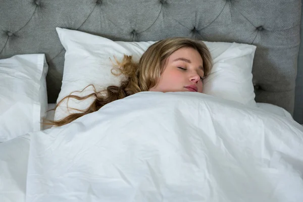 Mujer joven durmiendo en su cama —  Fotos de Stock