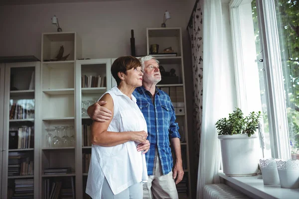 Senior paar op zoek door raam — Stockfoto