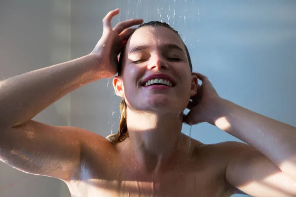Femme prenant une douche dans la salle de bain — Photo