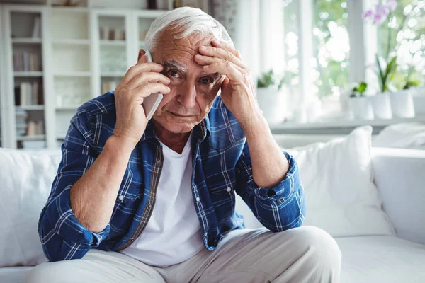 Tensed senior man talking on phone — Stock Photo, Image