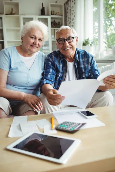 Senior para uśmiechający się podczas sprawdzania rachunków — Zdjęcie stockowe