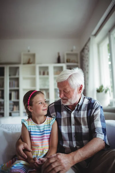 Senior man sitting with his granddaughter — Stock Photo, Image
