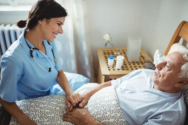 Krankenschwester hält Hand an älteren Mann — Stockfoto