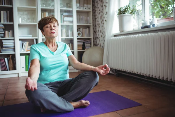 Mujer mayor meditando en posición de loto —  Fotos de Stock