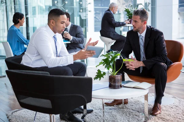 Businessmen having discussion over digital tablet — Stock Photo, Image