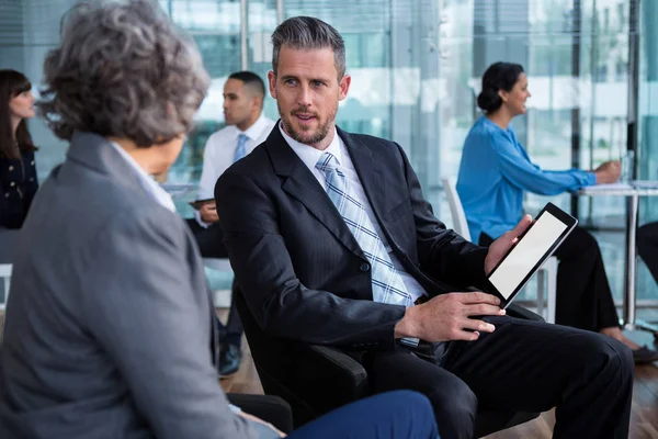 Uomini d'affari che discutono su tablet digitale — Foto Stock