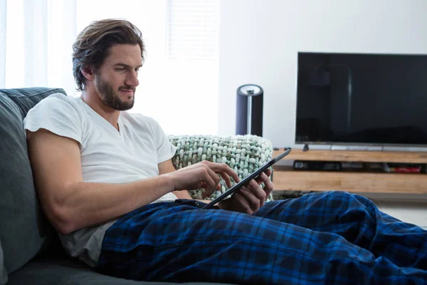 Homem usando tablet digital na sala de estar — Fotografia de Stock