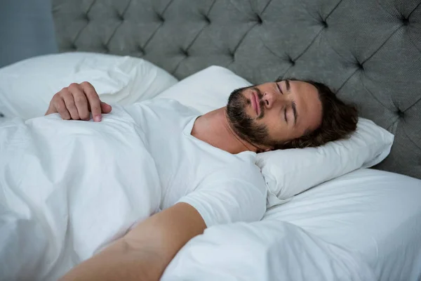 Человек спит на своей кровати — стоковое фото
