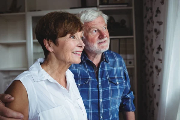 Senior paar op zoek door raam — Stockfoto