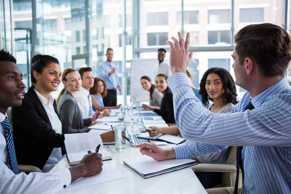 Colleague raising hand during meeting — Stock Photo, Image