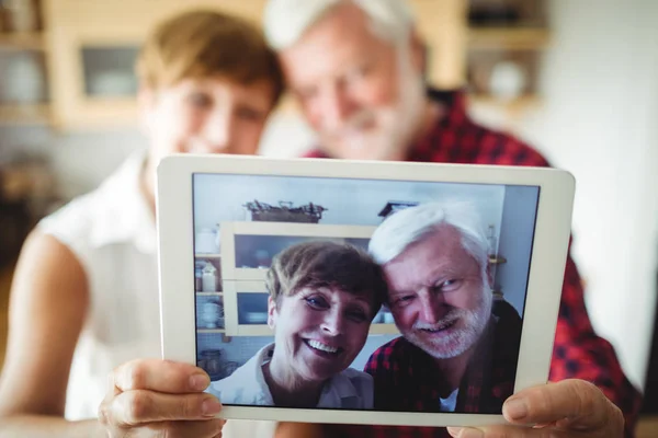 タブレット上の画像をクリックすると年配のカップル — ストック写真