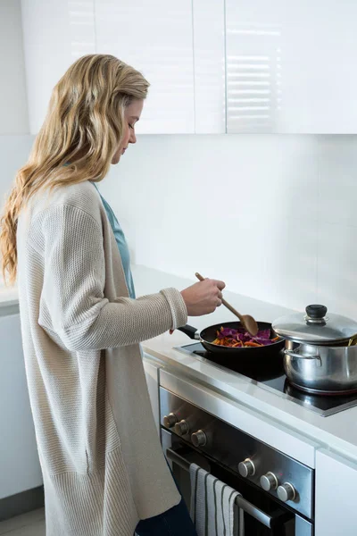 Mujer cocina comida en la cocina — Foto de Stock