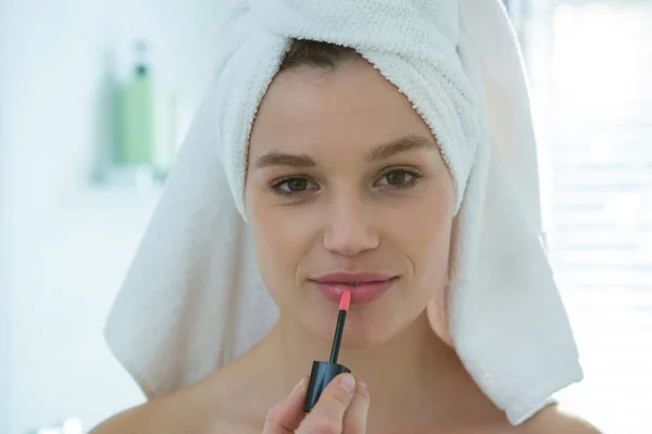 Mujer que aplica brillo labial en los labios —  Fotos de Stock