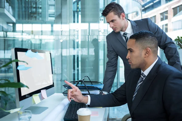 Empresários discutindo à mesa por computador — Fotografia de Stock