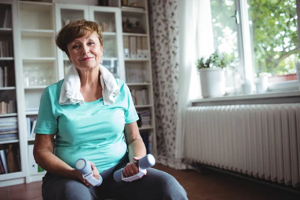 Senior woman sitting on exercise ball with dumbbells — Stock Photo, Image