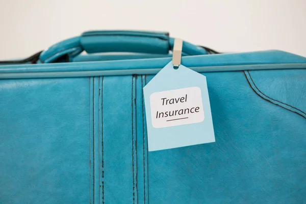 Bir bavul seyahat sigortası etiket bağlı — Stok fotoğraf