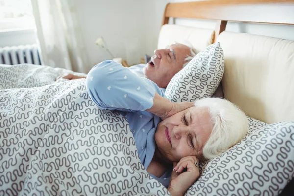 Hombre roncando y mujer cubriendo sus oídos — Foto de Stock