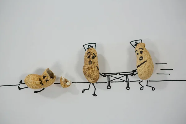 Peanut figurine providing medical assistance — Stock Photo, Image
