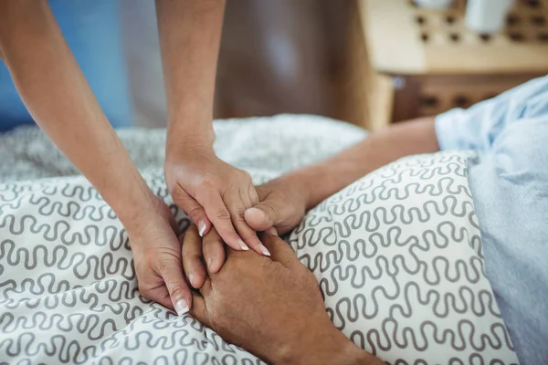 Krankenschwester hält Hand von Seniorin — Stockfoto