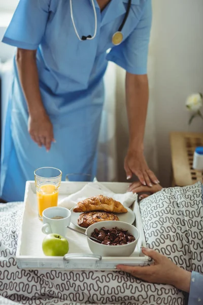 Νοσοκόμα σερβίρει πρωινό σε ανώτερους γυναίκα — Φωτογραφία Αρχείου