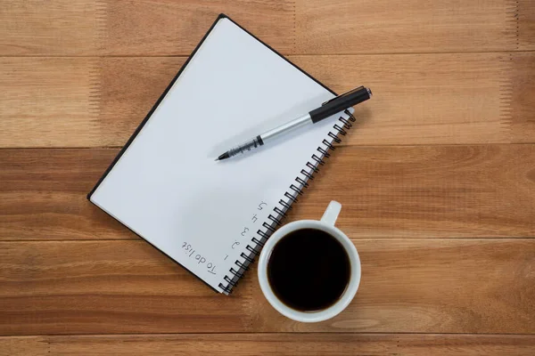 Nahaufnahme der Kaffeetasse mit Tagebuch und Stift — Stockfoto