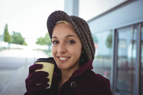 Γυναίκα, χαμογελαστά και κρατώντας ένα φλιτζάνι καφέ — Φωτογραφία Αρχείου
