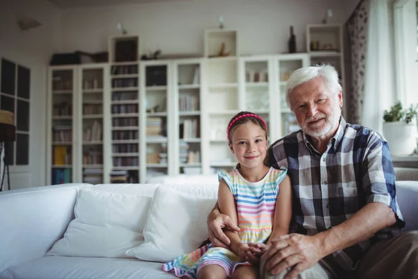 Porträtt av äldre man sitter med hans barnbarn — Stockfoto