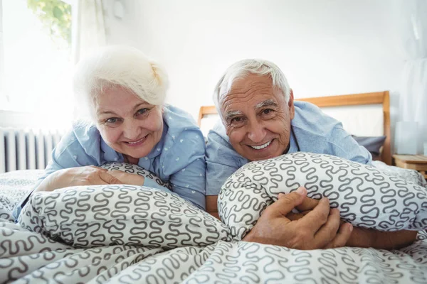 Couple âgé souriant sur le lit — Photo