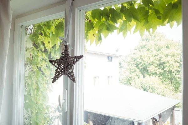 Estrela de vime pendurada em uma janela — Fotografia de Stock