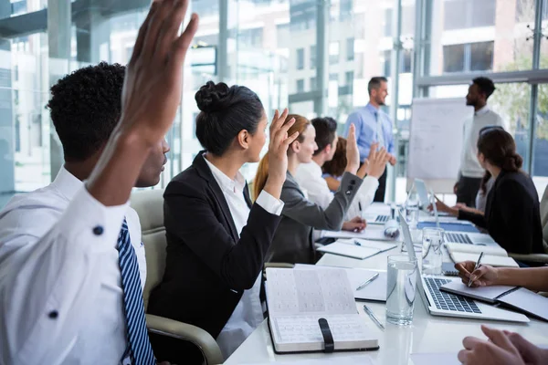 Collega's, het verhogen van hun handen tijdens vergadering — Stockfoto