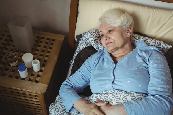 Worried senior woman relaxing on bed — Stock Photo, Image