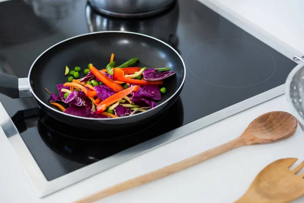 Voedsel op een inductie kookplaat in de keuken — Stockfoto