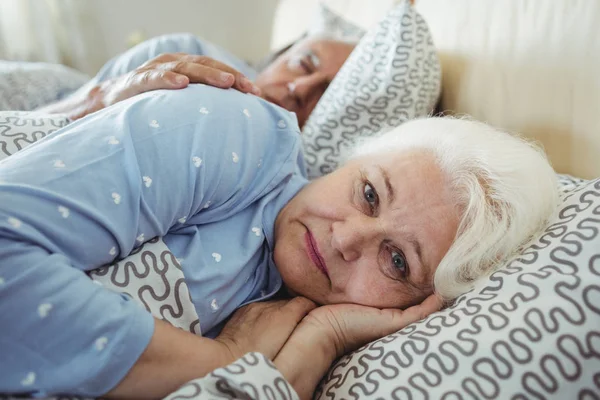 Senior vrouw wakker op bed — Stockfoto