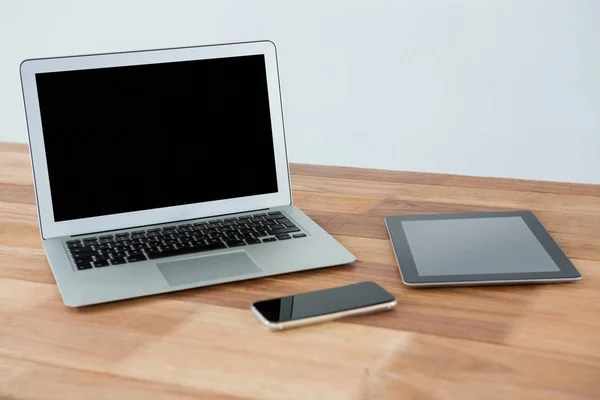 Laptop, tablet digital e telefone na mesa — Fotografia de Stock