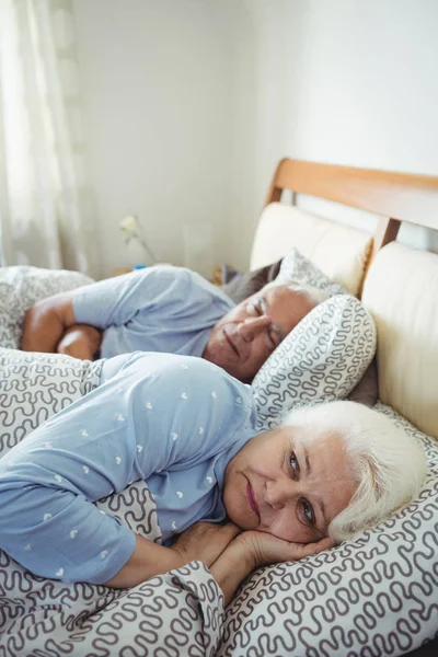 Senior woman awake on bed — Stock Photo, Image