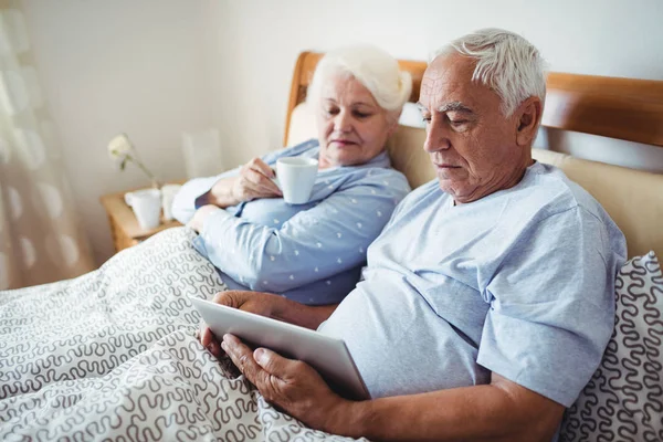 Senior kobieta o kawę i człowiek za pomocą tabletu — Zdjęcie stockowe