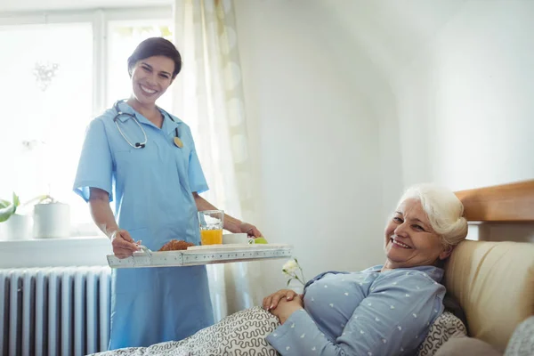 Pielęgniarka porcji śniadania do starszych kobiety — Zdjęcie stockowe