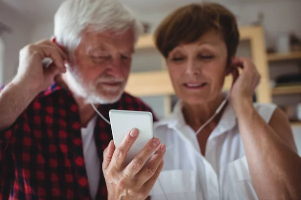 Senior couple listening to music on smartphone — Stock Photo, Image