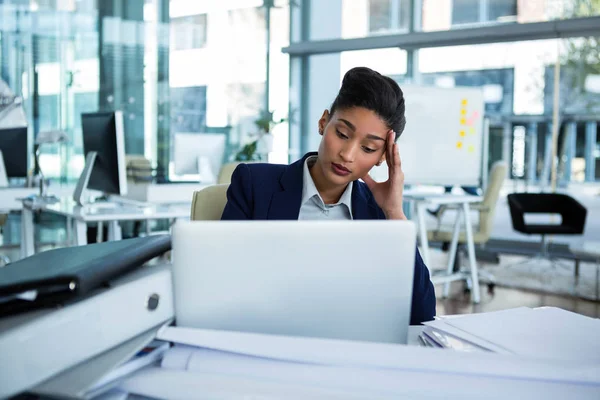 Mujer de negocios estresada sentada en su escritorio — Foto de Stock