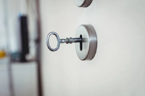 Llave en la puerta contra fondo borroso —  Fotos de Stock