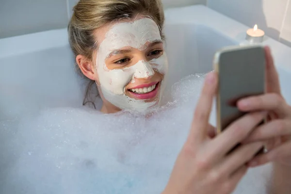 Mujer usando el teléfono móvil mientras se bañan —  Fotos de Stock