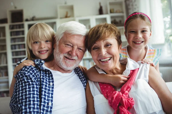 Porträtt av far-och morföräldrar leende med sina barnbarn — Stockfoto