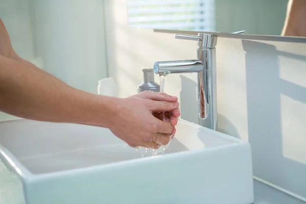 Человек моет руки в ванной раковине — стоковое фото