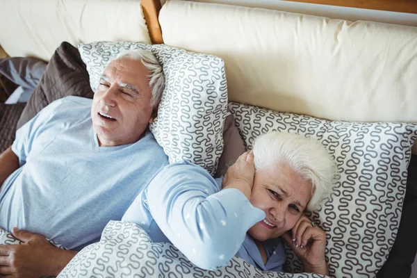 Hombre roncando y mujer cubriendo orejas — Foto de Stock