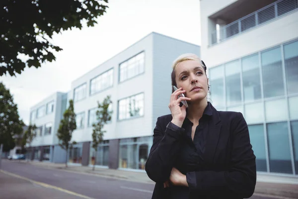 Thoughtful businesswoman standing with arms crossed — Stock Photo, Image